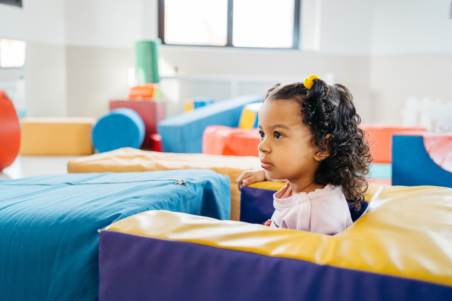 A young learner looking attentively across a colourful learning environment